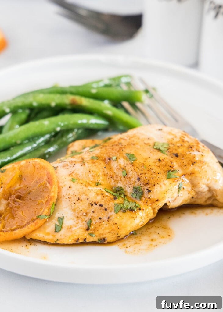a white plate with orange glazed chicken and green beans