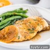 close up chicken breast with orange glaze on white plate