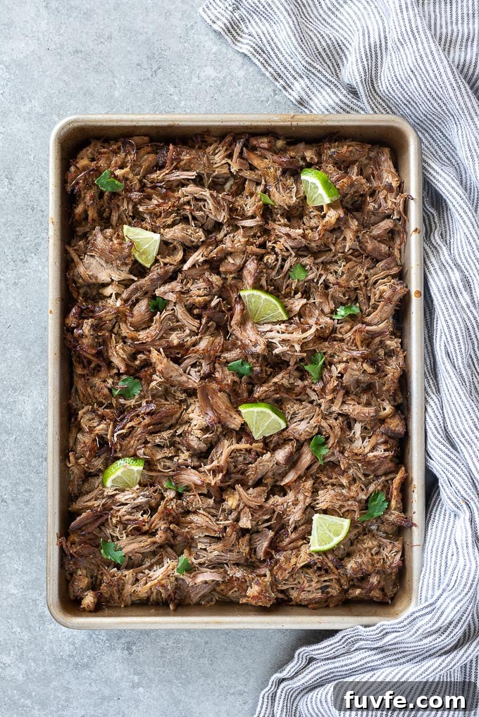 Baking sheet with shredded pork carnitas, lime and cilantro