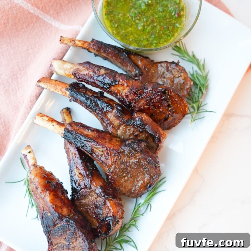 Juicy Garlic Butter Lamb Chops with Rosemary Guide 2 Lamb chops with a side of mint chimichurri on a plate with visible herbs and a glossy seared crust.
