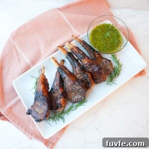 Juicy Garlic Butter Lamb Chops with Rosemary Guide 8 Lamb chops with a side of mint chimichurri on a plate with visible herbs and a glossy seared crust.