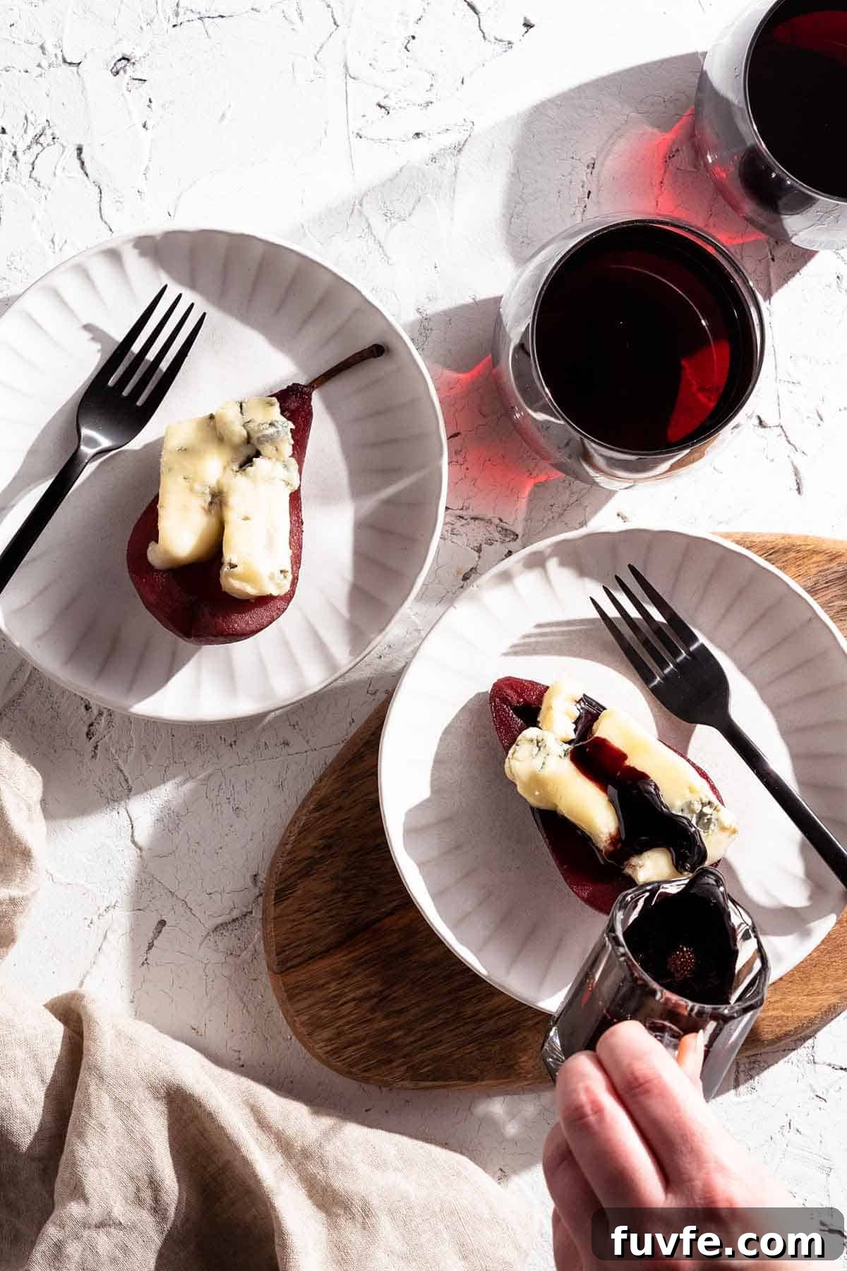 wine syrup being poured over poached pear
