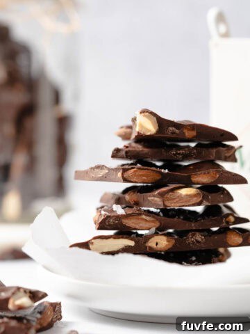 chocolate almond bark in stack on white plate.