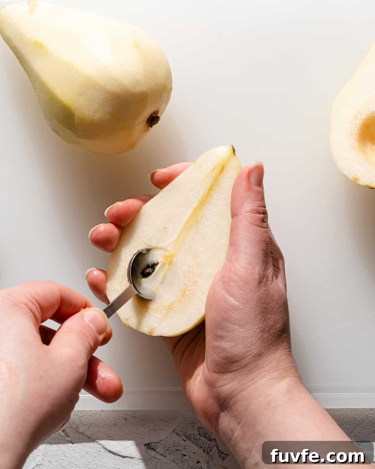 teaspoon scooping seeds out of peeled pear