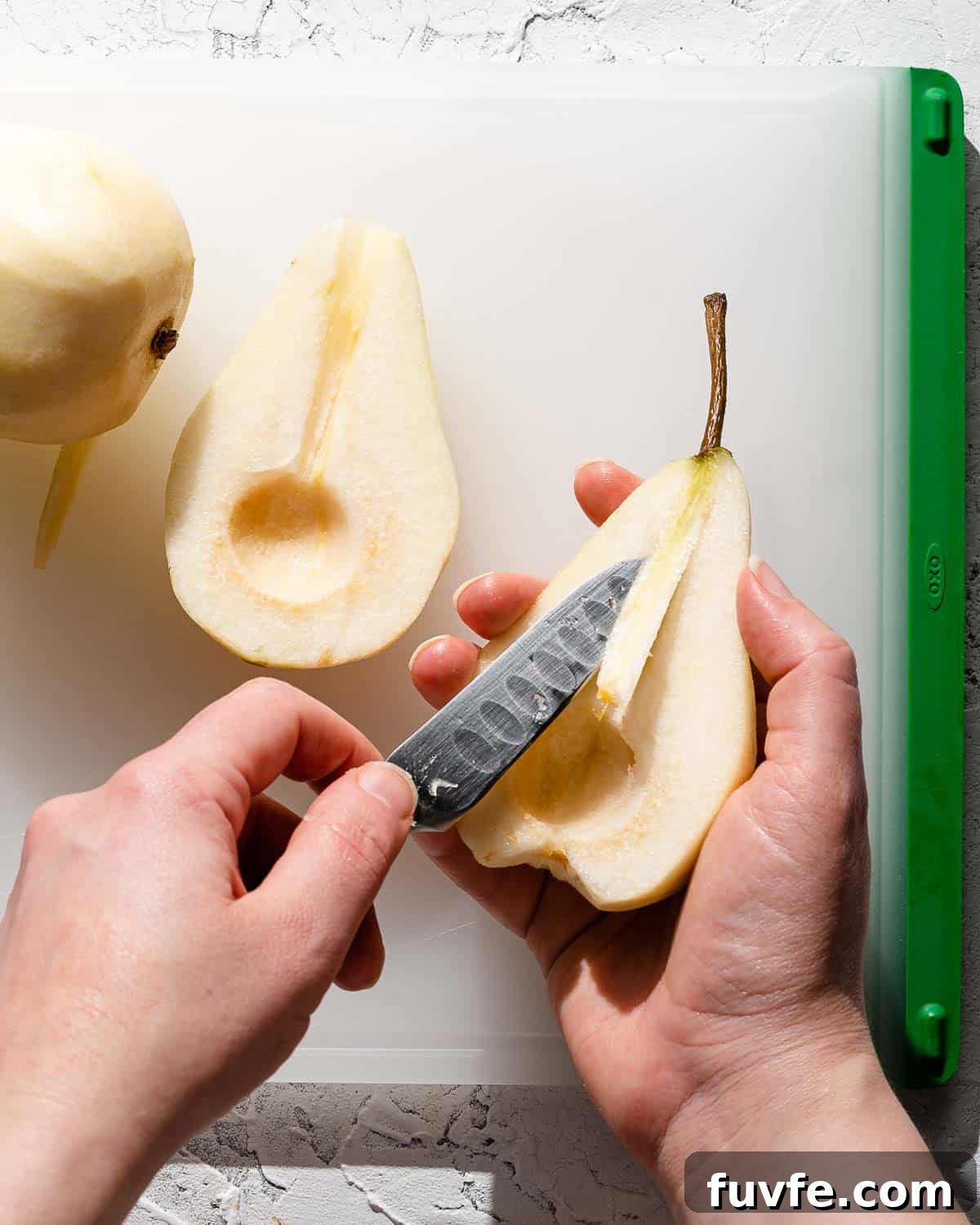 paring knife cutting stem out of center of pear