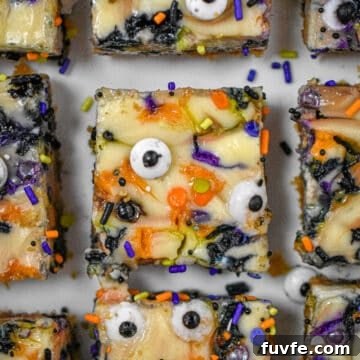 Nine Halloween Cheesecake Funfetti Bars are on a serving plate. This is a close up shot of them from above.