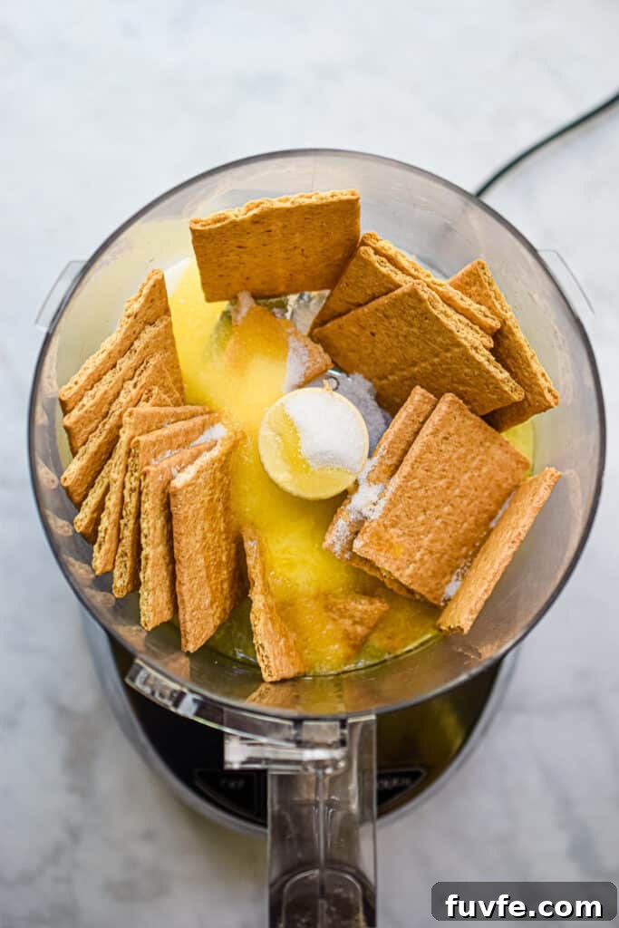 The graham crackers, sugar, and eggs are added to a food processor