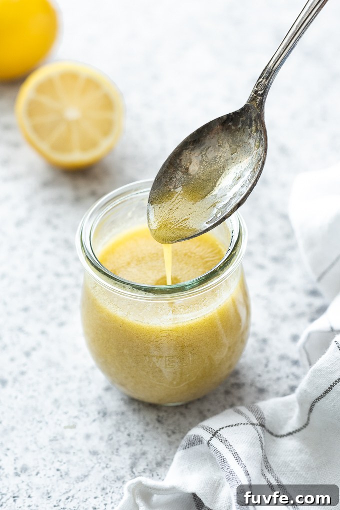 Lemon vinaigrette drizzling off of a spoon