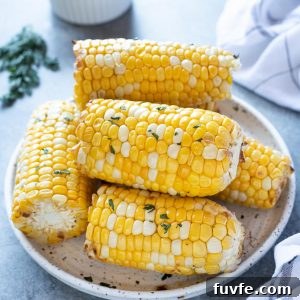Air fryer corn on the cob piled on a white plate