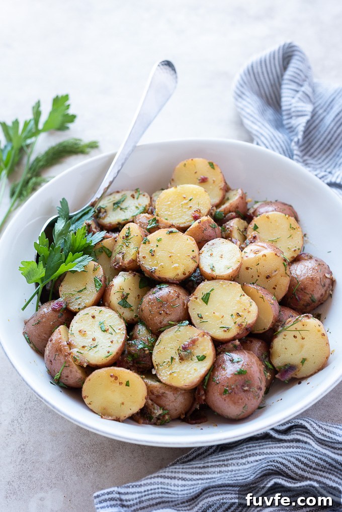 Authentic German Potato Salad Recipe 8 Warm german potato salad in a white bowl with a serving spoon