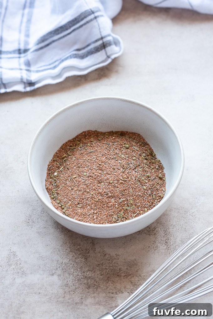 Homemade blackened seasoning in a white bowl with linen behind