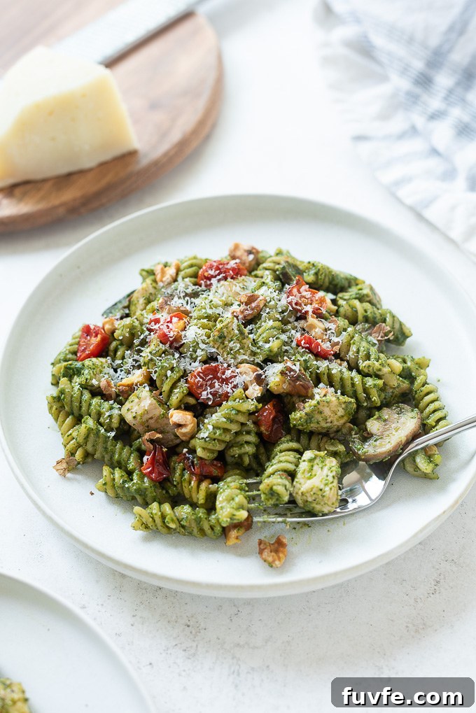 Plate of chicken pesto pasta with fork digging in