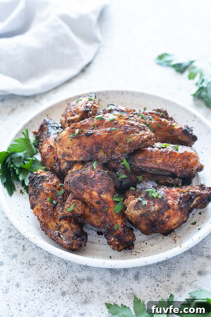 Air fryer chicken wings on a white plate with parsley