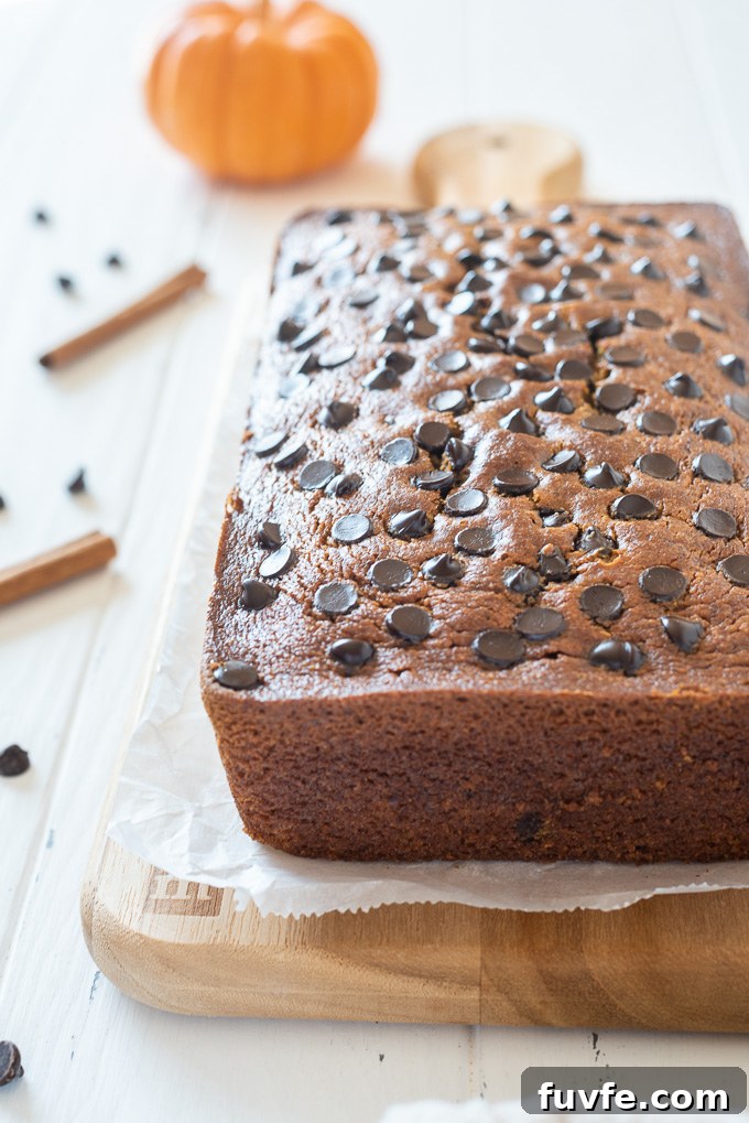 Loaf of Gluten-free pumpkin bread on a wooden cutting board