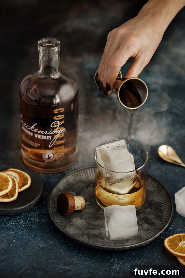 How to Make Smoked Ice at Home: Simple Steps for Cocktail Smoke Flavor 6 woman pouring bourbon in a glass over smoked ice cubes