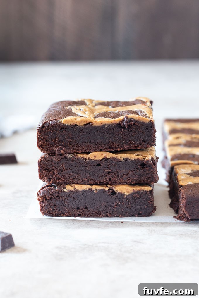 Fudgy Peanut Butter Brownies with Chocolate Swirl 3 Stack of peanut butter brownies on parchment paper