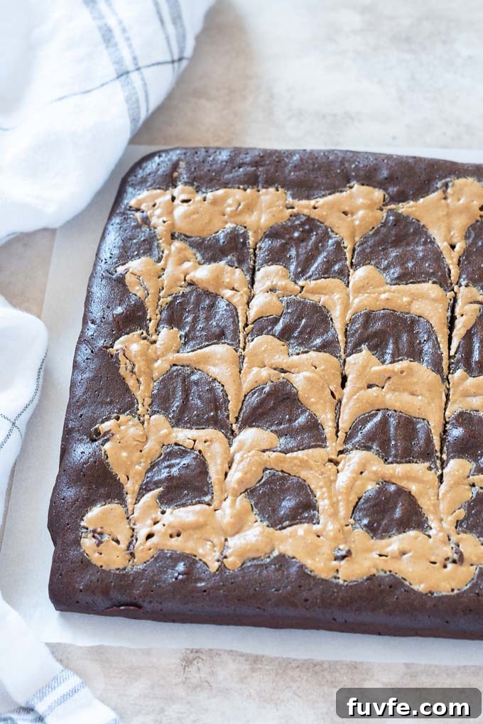 Fudgy Peanut Butter Brownies with Chocolate Swirl 6 Peanut butter swirl brownies on parchment before cutting