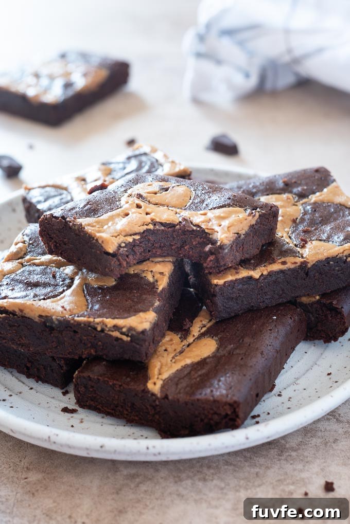 Fudgy Peanut Butter Brownies Recipe 7 Peanut butter brownies on a plate with bite out of top brownie