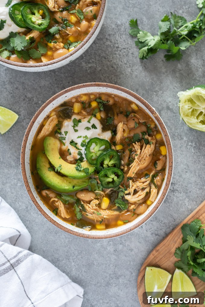 White bean chicken chili in a bowl topped with avocado and sour cream