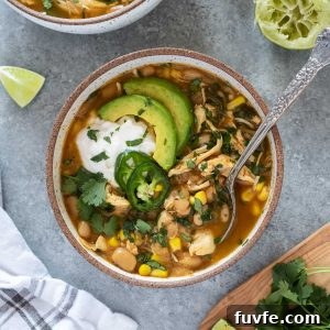 Bowl of instant pot white chicken chili with spoon digging in