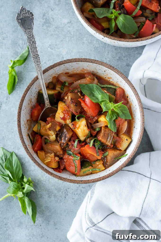 Bowl of ratatouille with a spoon buried inside