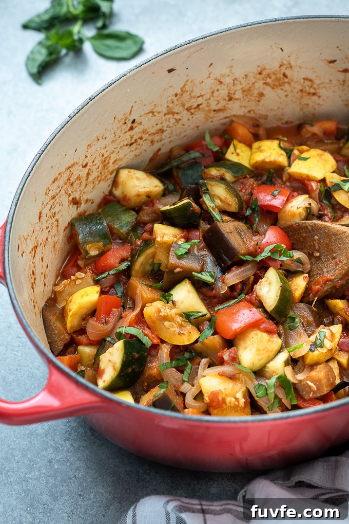 French ratatouille in a Dutch oven with a wooden spoon digging in