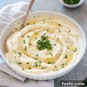 Bowl of garlic mashed cauliflower with spoon digging in