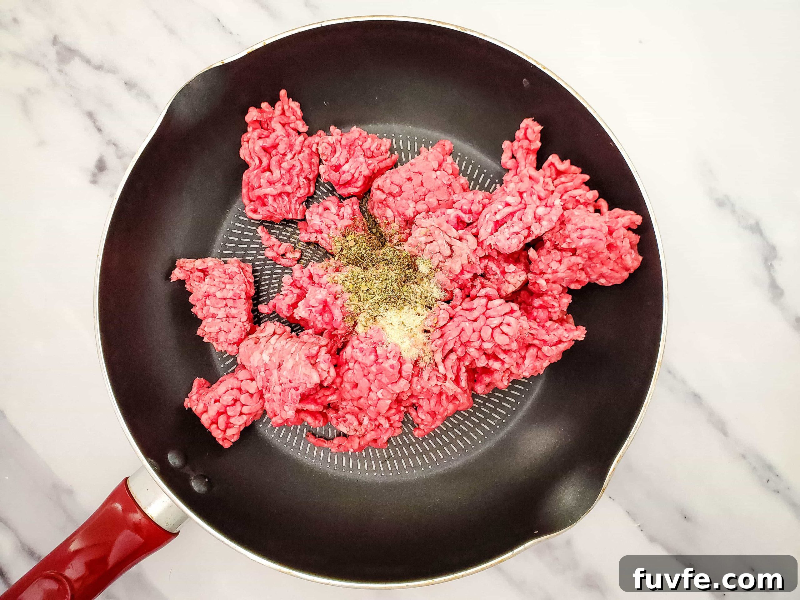 Quick Ravioli Lasagna Recipe for Fast Weeknight Dinners 3 Photo of cooking skillet with raw ground beef and spices.