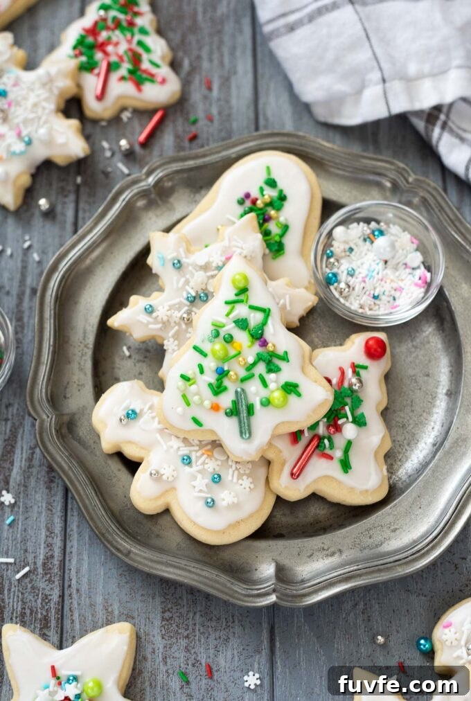 Christmas sugar cookies on a plate with sprinkles.