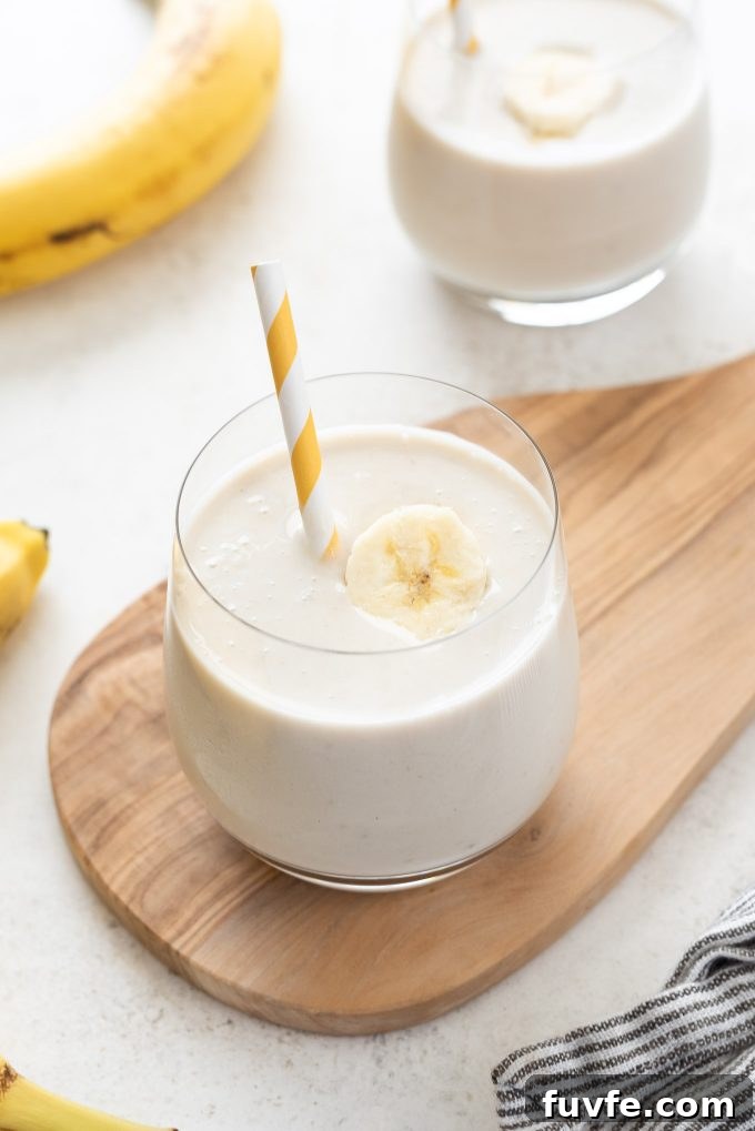 Creamy Banana Smoothie Recipe with Yogurt and Honey 2 Banana smoothie in a glass with straw and banana slice