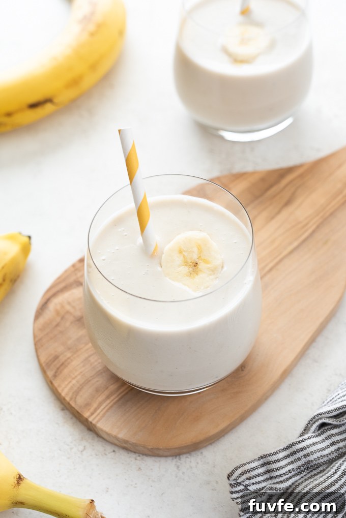 Creamy Banana Smoothie Recipe with Yogurt and Honey 6 Glass of banana smoothie on small wooden cutting board