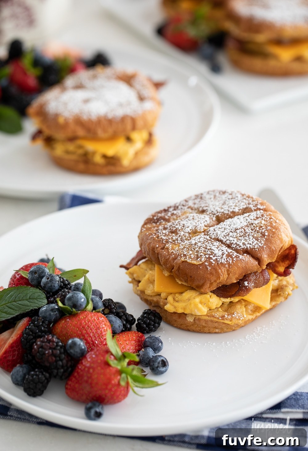 french toast breakfast sandwiches on plates on gingham napkins.
