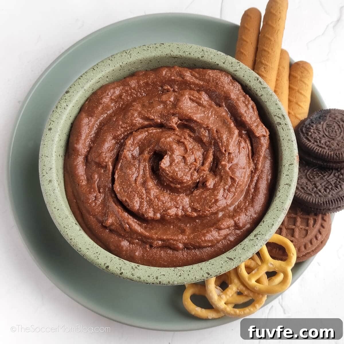 small bowl of chocolate hummus, with cookies and pretzels for dipping