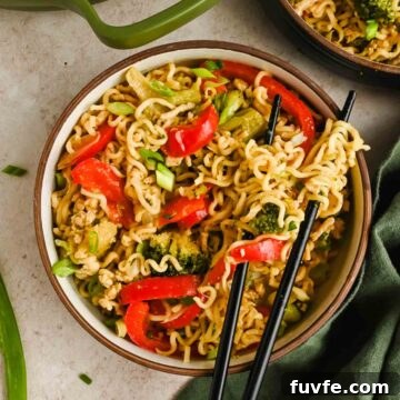 upgraded ramen with peppers, broccoli and edamame in serving bowl with black chopsticks.