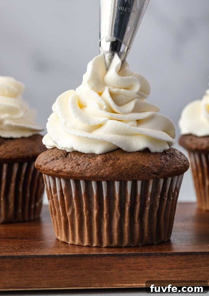 Stabilized whipped cream piping onto a cupcake