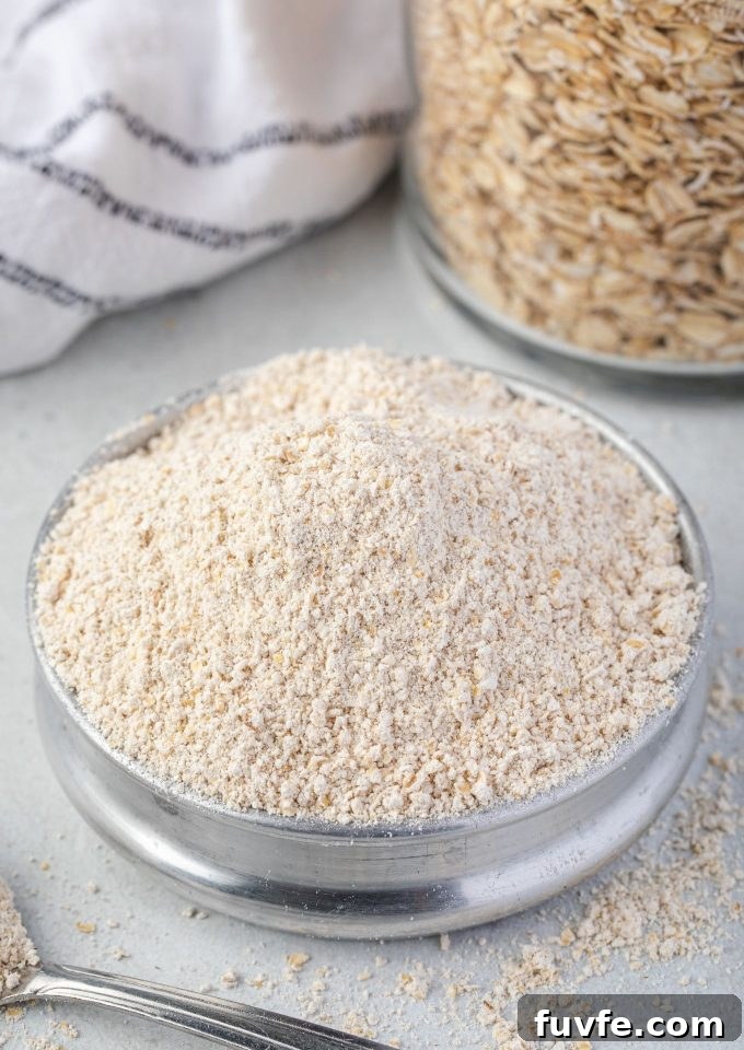 Oat flour in a bowl with jar of oats behind