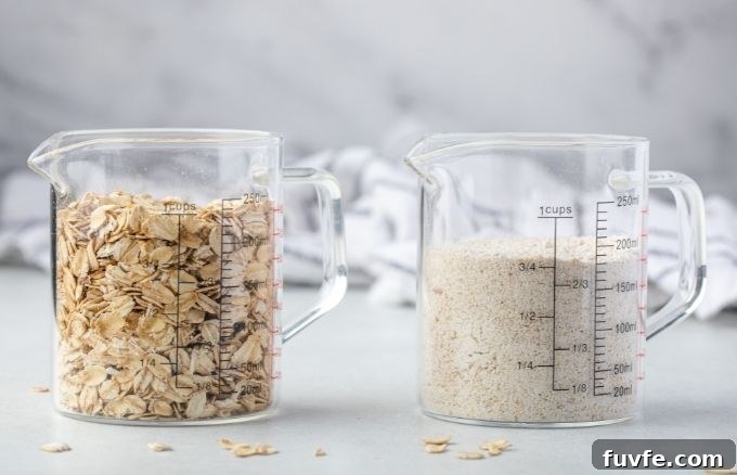 A measuring cup with 1 cup rolled oats next to one with 3/4 cup oat flour