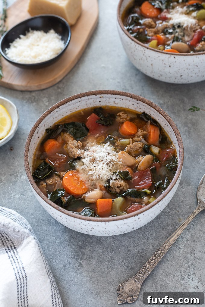Bowl of sausage kale soup with parmesan cheese on top
