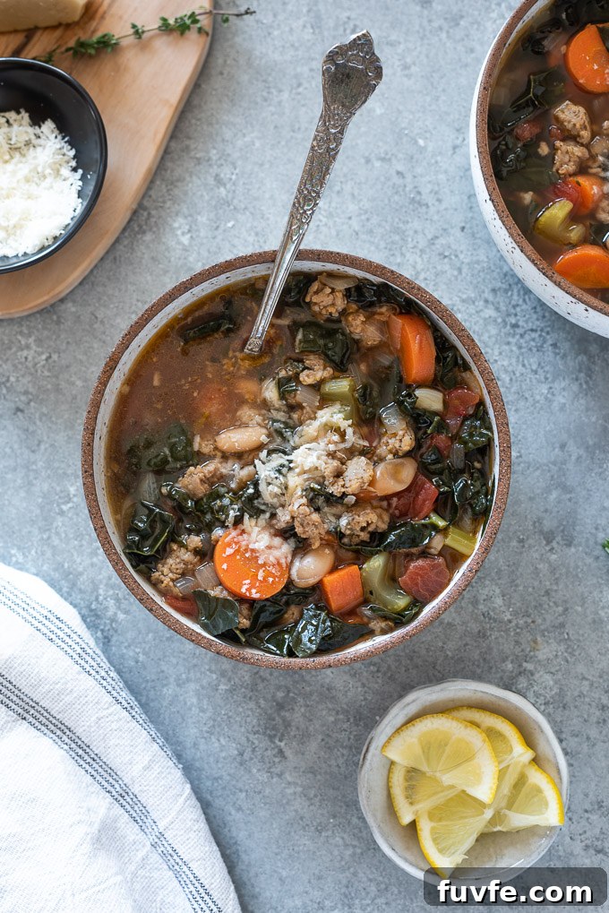 Spoon buried inside a bowl of sausage kale soup