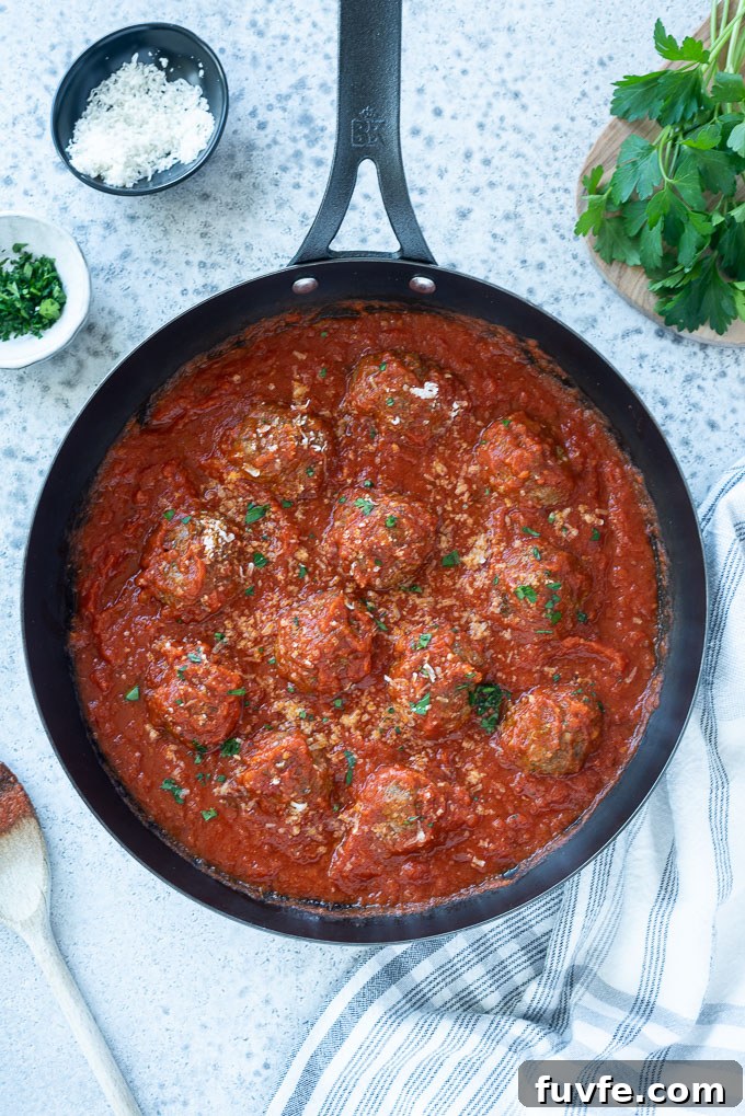 Oven baked Italian meatballs in a skillet with sauce