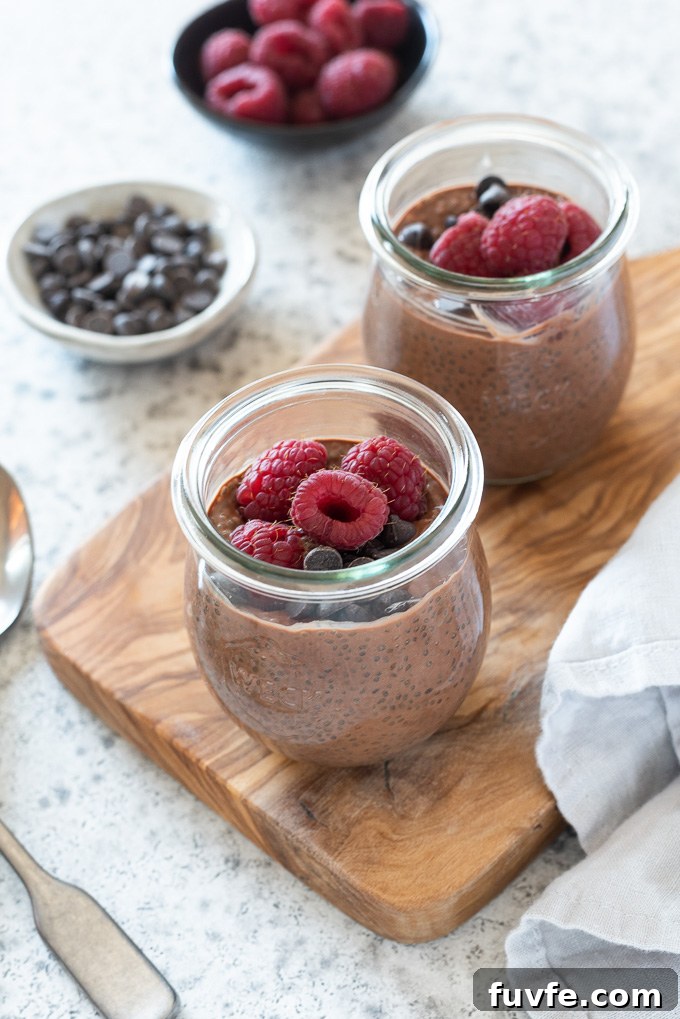 Decadent Chocolate Chia Seed Pudding Recipe 3 Chocolate chia pudding in jars topped with raspberries and chocolate chips