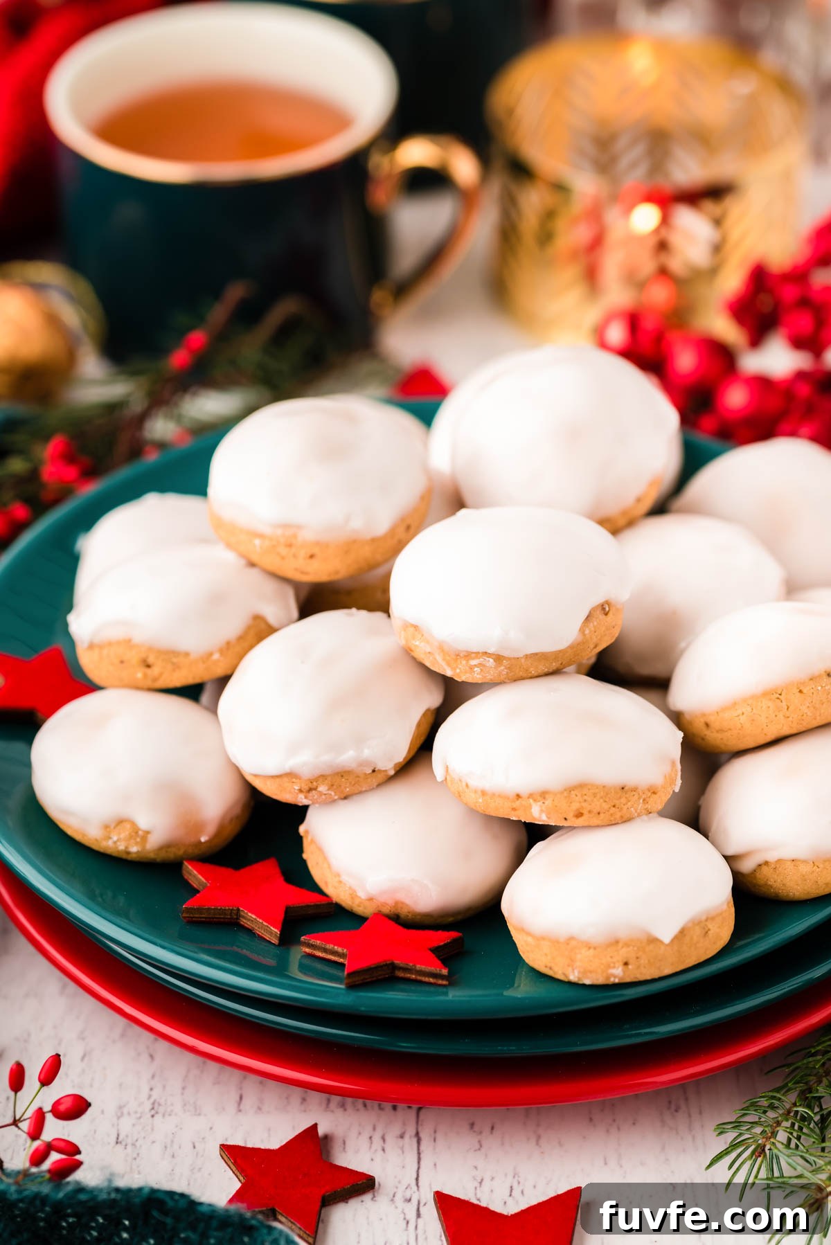 Close up photo of pfeffernusse cookies piled on a teal plate.