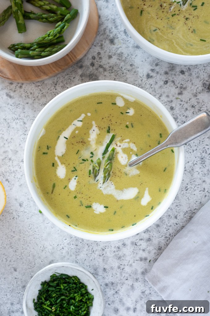 Asparagus soup with cream, asparagus tips and chives on top