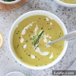 Creamy asparagus soup in a bowl with chives on top