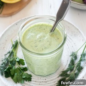 Green goddess dressing in a jar with a spoon