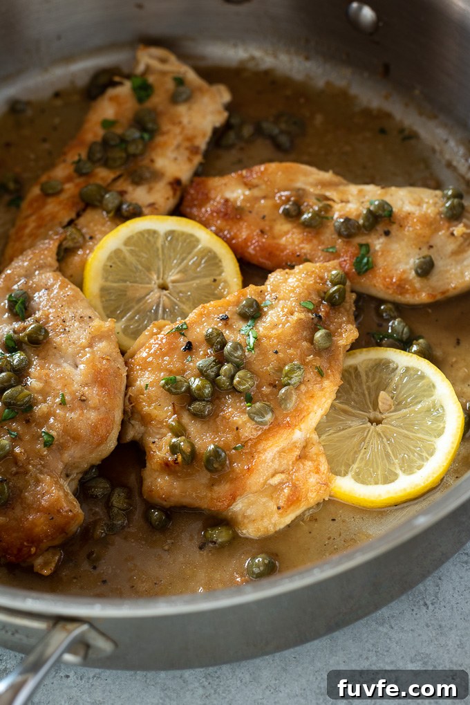 Weeknight Chicken Piccata Recipe with Lemon Caper Sauce 8 Chicken piccata in a pan with sauce and lemons