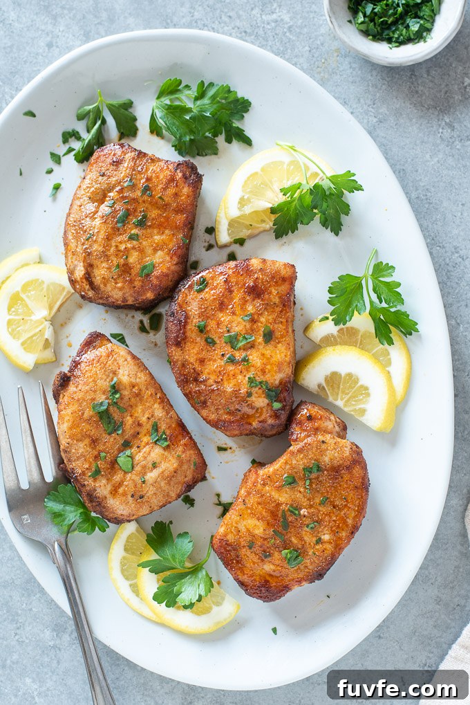 Platter of air fryer boneless pork chops with lemon and parsley