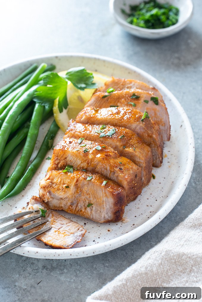 Crispy, Juicy Air Fryer Pork Chops 7 Sliced air fryer pork chop on plate with green beans