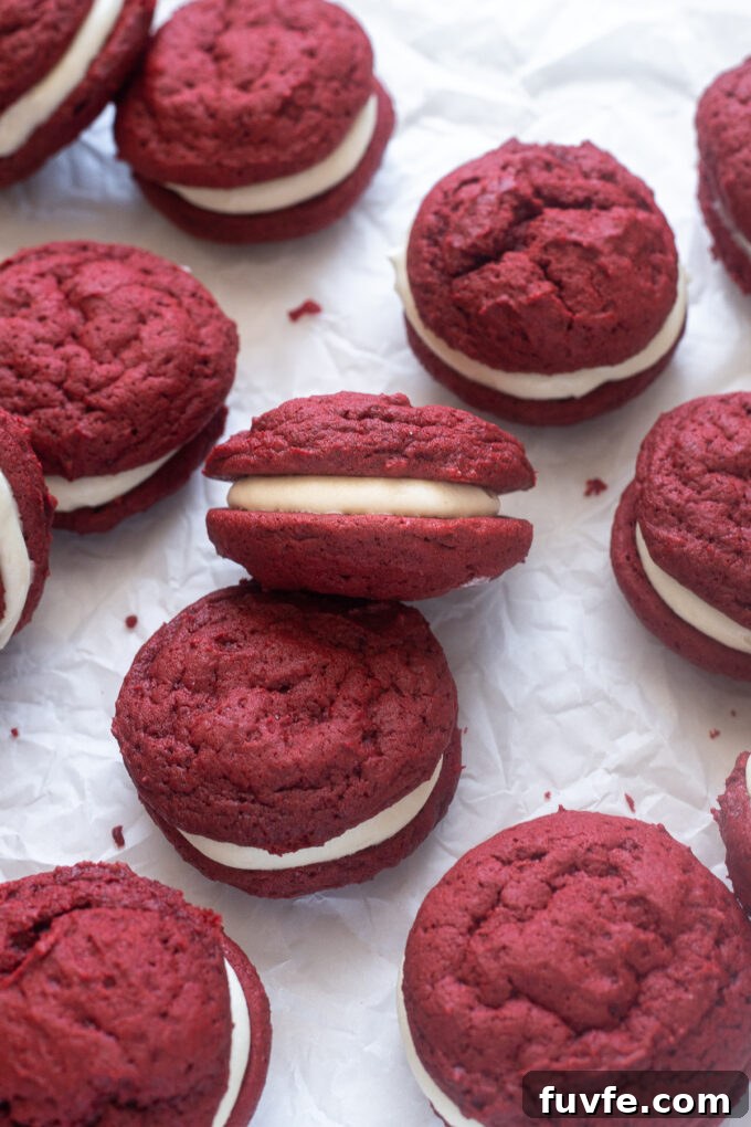 Red velvet whoopie pies scattered about on parchment paper.