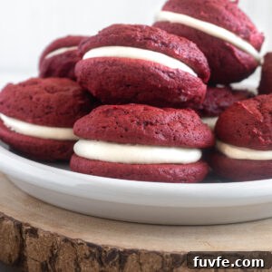 Red velvet whoopie pies piled on a plate.